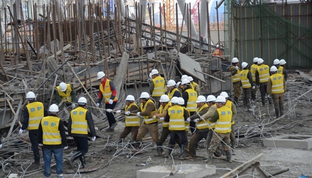 Rescue workers search at the site where a power plant's cooling tower under construction collapsed in Fengcheng, Jiangxi province, China