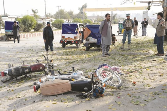 Security forces inspect the wreckage after an explosion that targeted a police ranger vehicle in Jalalabad yesterday.