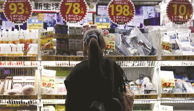 A woman looks at items outside a store at a shopping district in Tokyo. Japanu2019s core consumer prices marked their eighth straight month of annual declines in October, illustrating the sheer scale of the central banku2019s struggle to beat deflation and stagnant growth with diminishing policy options.