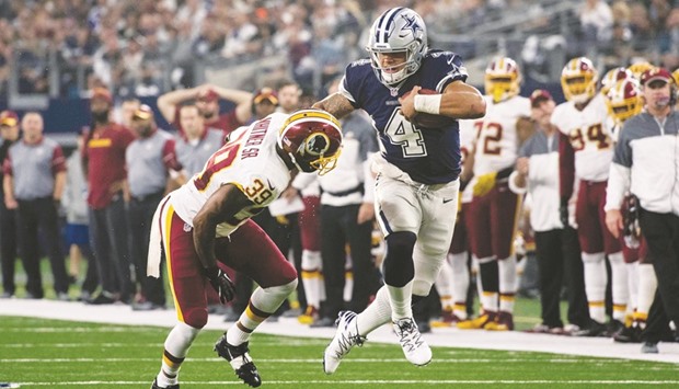 Dallas Cowboys quarterback Dak Prescott (right) stiff arms Washington Redskins strong safety Donte Whitner Sr during the second quarter of the NFL at AT&T Stadium in Arlington, Texas, on Thursday. (USA TODAY Sports)