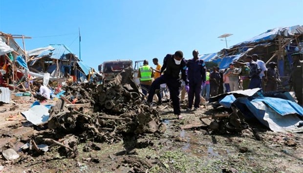Explosive experts assess the wreckage of destroyed cars after an explosion in Mogadishu on Saturday.