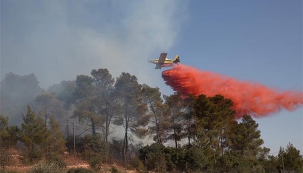 An Israeli firefighting plane helps extinguish a fire over the Halamish settlement, northwest of Ramallah, on Saturday.