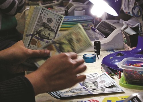 A money changer counts US dollar bills at a currency exchange in Manila. The dollaru2019s rise to the highest level in more than a decade leaves traders looking for clues to the rallyu2019s sustainability with a US jobs report next week looming as the next milestone.
