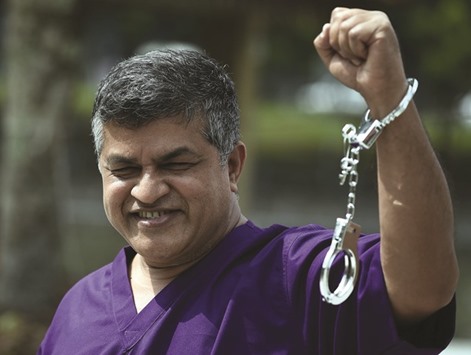 File photo shows Malaysian cartoonist Zulkiflee Anwar Ulhaque, popularly known as Zunar, posing with handcuffs ahead of a book-launch event in Kuala Lumpur.