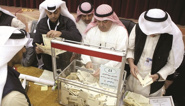 A Kuwaiti judge and his aides count the ballots at a polling station at the end of the vote in the Sabah al-Salem district on the outskirts of Kuwait City yesterday.