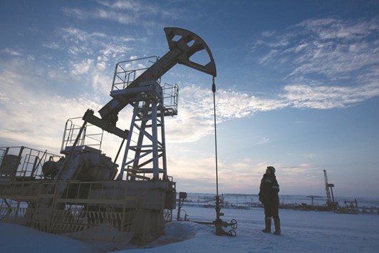 A worker inspects a pumping jack during oil drilling operations in an oilfield operated by Bashneft in Russia. With its oil output at record levels and state coffers  running low, Russia has little to lose and much to gain from agreeing a deal with the Opec on limiting production.
