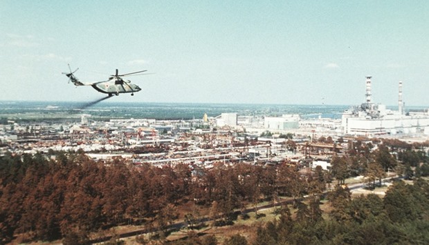 This undated handout picture from Russian news agency Tass shows a military helicopter spreading stuff supposed to reduce the contamination of the air full of radioactive elements above the Chernobyl nuclear plant, days after its No. 4 reactoru2019s blast, the worldu2019s worst nuclear accident of the 20th century.