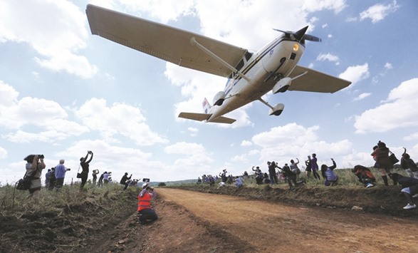A plane flies over spectators during the Vintage Air Rally at the Nairobi National Park yesterday.