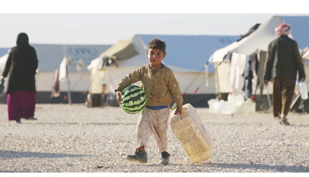 An Iraqi boy, who fled Mosul with his family, carries a ball at the UN-run Al Hol refugee camp in Syriau2019s Hasakeh province.