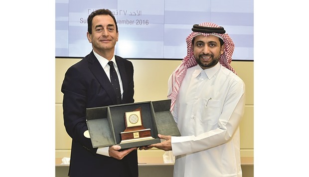 Dr Eric Chevallier receiving a memento from Dr Hassan al-Derham yesterday.