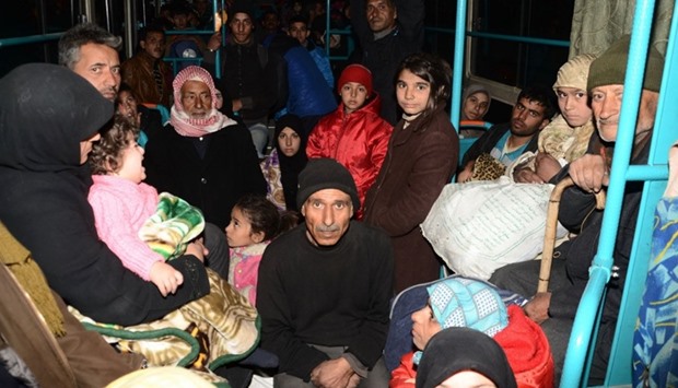Syrian families, from various eastern districts of Aleppo, are evacuated by bus through Sheikh Maqsud, a Kurdish-controlled enclave between the government-held west of Aleppo and the east.