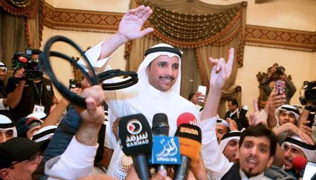 Kuwaiti candidate and former parliament speaker Marzouq al-Ghanem (C), celebrates with his supporters following the announcement of his victory in the parliamentary election, yesterday in Kuwait city
