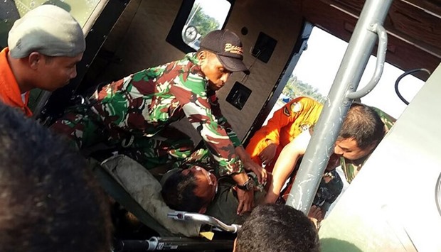 Indonesian pilot Abdi Damain (R-lying down) being rescued as they fly from Malinau to Tarakan in North Kalimantan