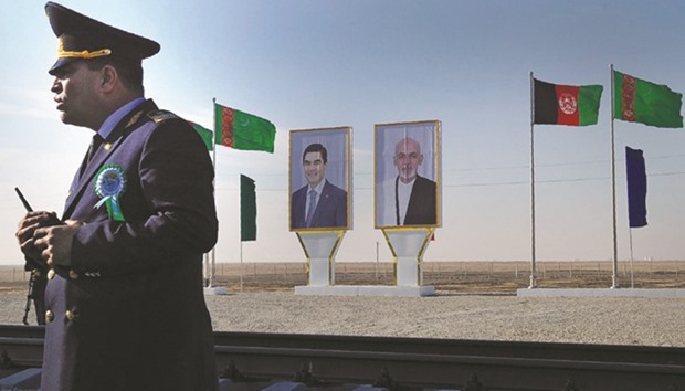 Posters with portrait of Turkmenistanu2019s President Gurbanguly Berdymukhamedov and his Afghan counterpart Ashraf Ghani are seen at Turkmenistanu2019s Imamnazar customs point yesterday, during a ceremony marking the opening of the first section of a $2bn railway link between the two countries.