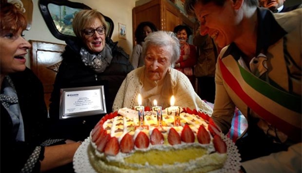 Emma Morano, thought to be the world's oldest person and the last to be born in the 1800s, reacts in front of her 117th birthday cake in Verbania, northern Italy on Tuesday.