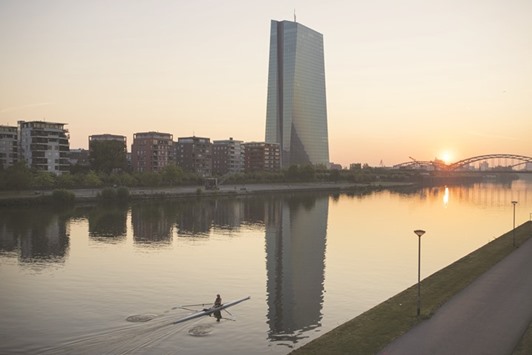 A rower paddles on the River Main on sun rise, as the ECB headquarters stands beyond in Frankfurt. The ECB could use its u20ac80bn ($84.8bn) monthly bond-buying programme to counter any immediate, further spike in bond yields after Sundayu2019s crucial referendum, smoothing market moves and supporting bonds, according to four eurozone central bank sources who asked not to be named.