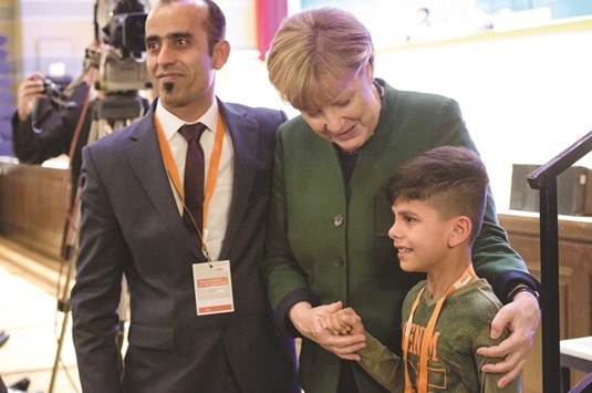 Merkel with Edris and his father at the regional CDU conference in Heidelberg, western Germany. Edris attended the conference and took the occasion to thank Merkel.