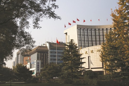 The Peopleu2019s Bank of China headquarters (right) is seen in Beijing. After keeping the yuan steady at around 6.7 per dollar from July through September, the PBoC has since allowed the currency to weaken beyond 6.9, a level last seen during the global financial crisis in 2008.