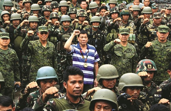 President Rodrigo Duterte raises a clenched fist with military top brass as he visits troops in Nanagun, Lombayanague in Lanao del Sur in Mindanao island yesterday.