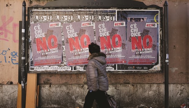 A woman walks past posters in support of the u2018Nou2019 vote in Rome.