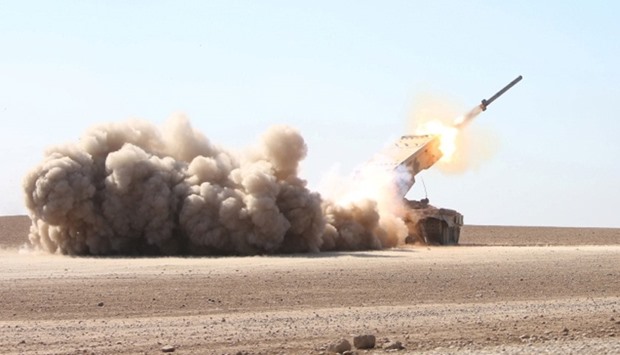 Iraqi security forces launch a rocket towards Islamic State militants