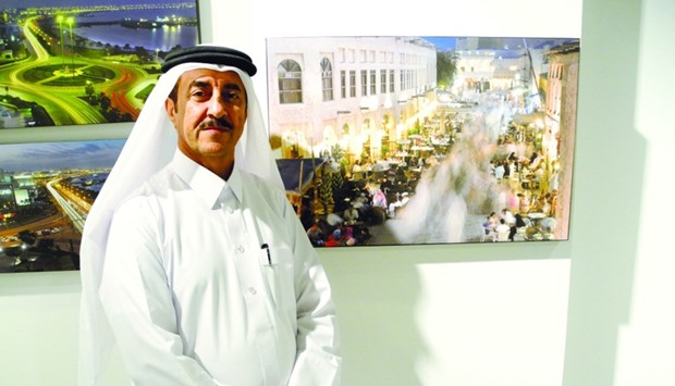 Qatar-based professional photographer Mohamed al-Hasel al-Yafei with three of his photographs currently on exhibit at Katara's Building 18. PICTURE: Peter Alagos