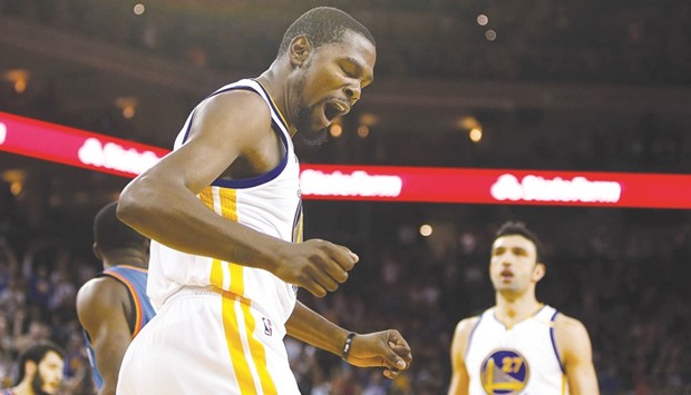 Kevin Durant (left) of the Golden State Warriors reacts after dunking the ball against the Oklahoma City Thunder at Oracle Arena in Oakland, California, on Thursday. (AFP)