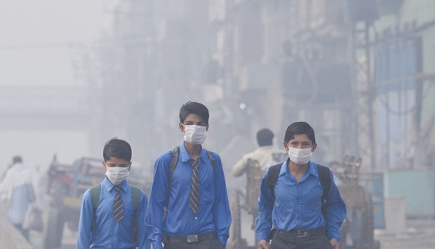 School students return home as heavy smog envelops the city in Lahore yesterday.