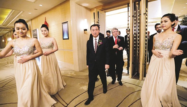Wang Jianlin, chairman of Dalian Wanda Group (left), and Atletico Madridu2019s president Enrique Cerezo arrive for a signing ceremony in Beijing. The Chinese firm has sought to transform its business in the face of uncertainties in Chinese real estate, and has invested heavily in film, buying Hollywood studio Legendary Entertainment earlier this year.