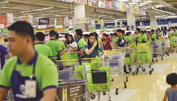 Employees load up shopping carts at a supermarket in Paranaque city, Metro Manila. The International Monetary Fund is forecasting growth of 6.7% in the Philippines.