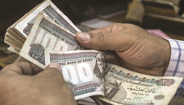 A man counts Egyptian pounds at a currency exchange shop in downtown Cairo on Thursday. For a country like Egypt thatu2019s always managed its exchange rate, the transition will be tough.