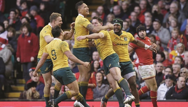 Australiau2019s Bernard Foley celebrates scoring a try with teammates during their match against Wales yesterday.