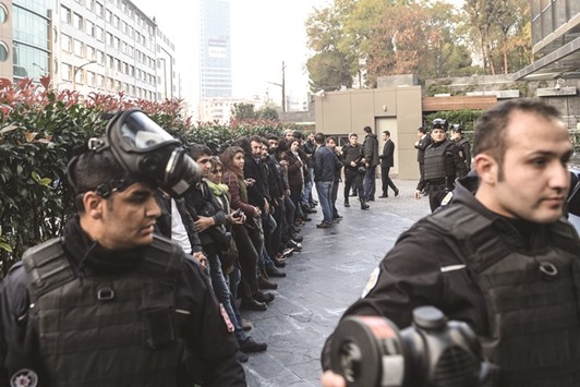 Protesters in Istanbul who have been detained yesterday by riot police wait to be processed.