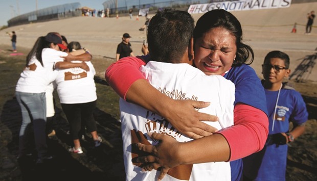 A file photo of relatives, separated by deportation and immigration, hug at the border during a brief reunification meeting at the banks of the Rio Bravo last month.