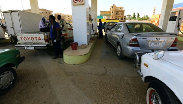 People gather to get fuel at a petrol station in Khartoum