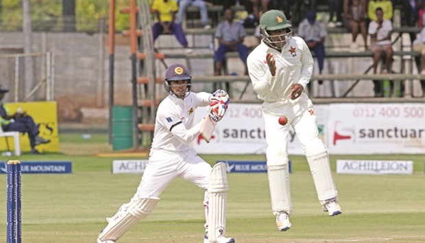 Sri Lanka batsman Dhananjaya de Silva (L) plays a shot as Brian Chari takes evasive action during the first day of the second cricket Test match in Harare yesterday.