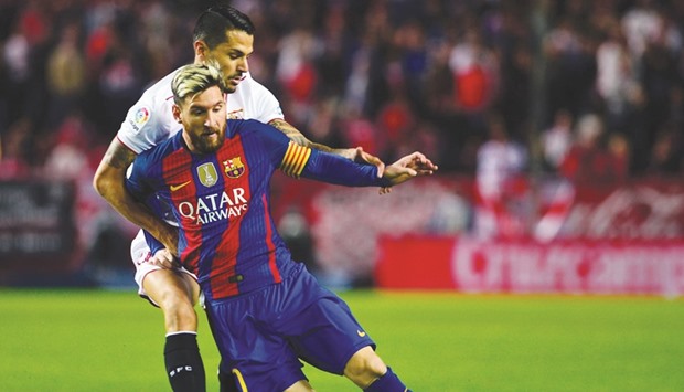 Barcelonau2019s Lionel Messi (right) vies for the ball with Sevillau2019s Vitolo during the Spanish league match at the Ramon Sanchez Pizjuan stadium in Sevilla on Sunday. (AFP)
