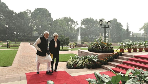 Prime Minister Narendra Modi walks with his British counterpart Theresa May at Hyderabad House in New Delhi yesterday.