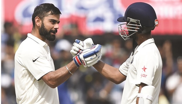File picture of Indiau2019s batsman and captain Virat Kohli (L) celebrating with teammate Ajinkya Rahane after scoring a double century against New Zealand.