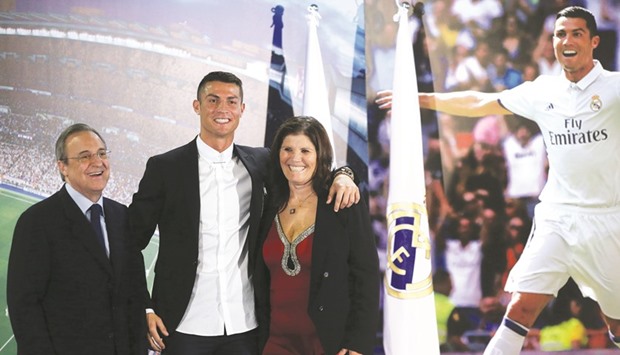 Real Madridu2019s Cristiano Ronaldo (C) poses with his mother Dolores Aveiro and the clubu2019s president Florentino Perez after a ceremony for his contract renewal.