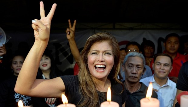 Governor Imee Marcos, daughter of the late dictator Ferdinand Marcos, flashes the peace sign which is commonly associated with her father, as she joins other supporters and waits for the Philippine Supreme Court to issue a decision on a petition to block President Rodrigo Duterte's plans to bury the late dictator Marcos at the Heroes' Cemetery, during a rally in front of the Supreme Court in Manila