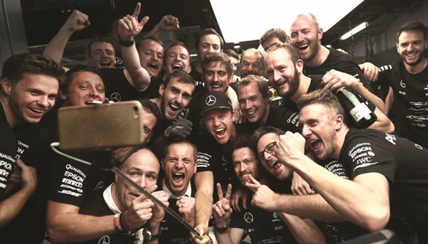 File picture of Mercedes AMG Petronas F1 Teamu2019s German driver Nico Rosberg (C) and crew members take a selfie at their paddock after the Formula One Japanese Grand Prix.