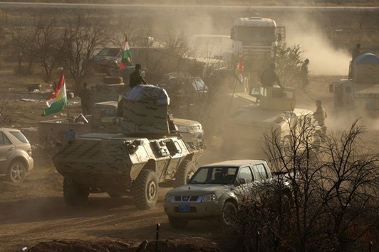 Military vehicles of Peshmerga forces drive in the town of Bashiqa, east of Mosul, during an operation to attack Islamic State militants in Mosul, Iraq, yesterday.