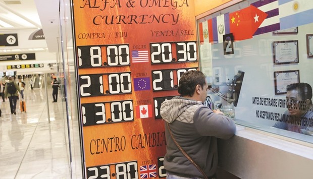 A board displaying the exchange rates of Mexican peso against the US dollar and the euro is seen at a foreign exchange house at the international airport in Mexico City. The peso tumbled to a record as Donald Trumpu2019s victory in US presidential elections raised the prospect that two decades of Mexican economic integration with its northern neighbour will unravel.