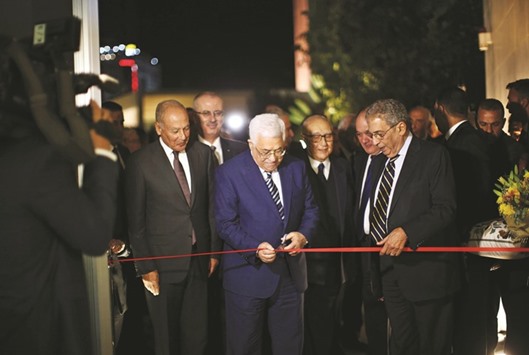 Palestinian President Mahmoud Abbas cuts the ribbon with Secretary General of the Arab League Ahmed Aboul Gheit (left) and former Arab League Secretary-General Amr Moussa (right) during the opening ceremony of an official museum commemorating the life and legacy of late Palestinian leader Yasser Arafat in the West Bank city of Ramallah yesterday.