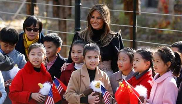 Melania Trump smiles with children holding US and China flags as she visits Beijing Zoo on Friday.