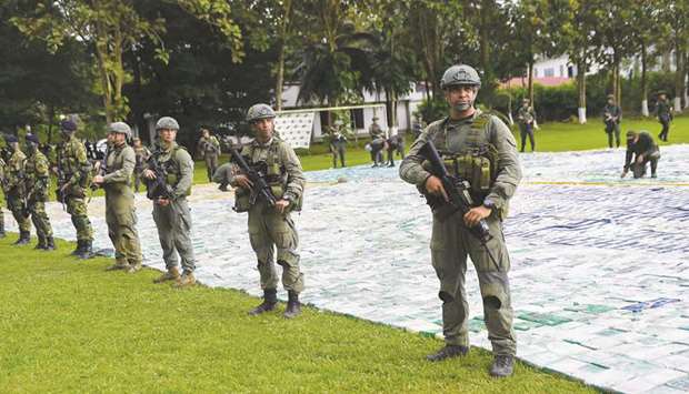 This handout picture released by Colombiau2019s presidency shows anti-narcotics police guarding over 12 tonnes of cocaine in Apartado, Antioquia, Colombia.