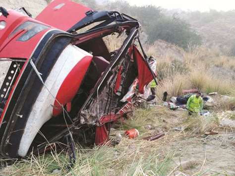 An overturned bus in Attock District of east Pakistanu2019s Punjab Province yesterday. At least 26 people were killed and several others injured when the passenger bus fell into a ravine on Wednesday night, police said.
