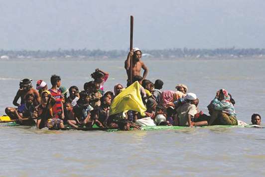 Rohingya refugees arrive near a shore on a makeshift boat after crossing the Bangladesh-Myanmar border, at Shah Porir Dwip, near Coxu2019s Bazar, Bangladesh.