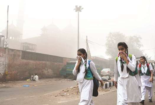 Schoolchildren cover their faces as they walk to school amid heavy smog in New Delhi.